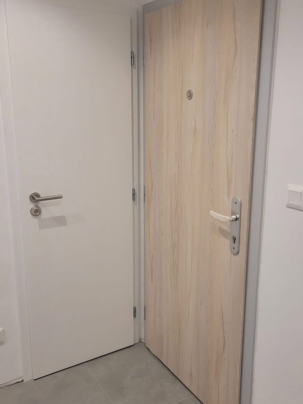Bezpečnostné dvere FORNOX vo svetlom dubovom drevodekore v bytovom interiéri