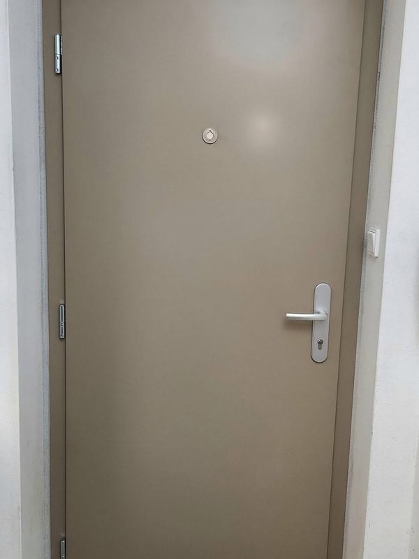 Bezpečnostné dvere FORNOX v béžovosivom odtieni po montáži v bytovom dome
