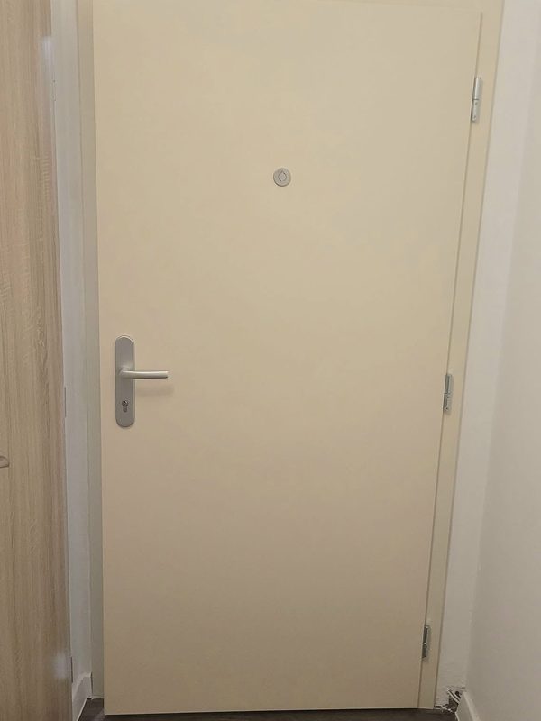 Krémovo biele bezpečnostné dvere FORNOX osadené v bytovom interiéri